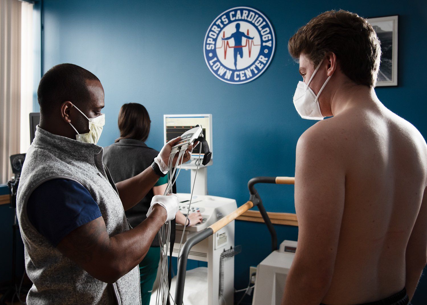 A man wearing a mask is being examined by a doctor at the sports carcinology center
