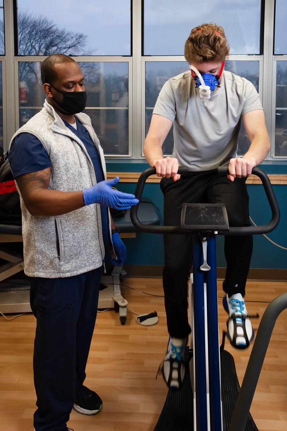 A man is wearing a mask while riding an exercise bike.