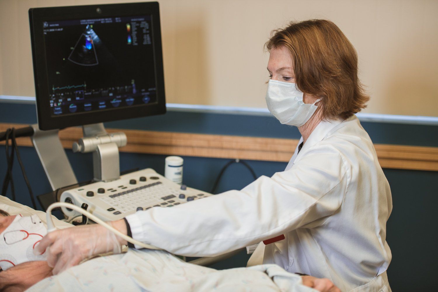 A female doctor is using an ultrasound machine on a patient.