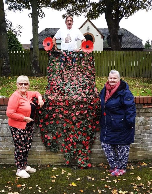 Villagers by a poppy display