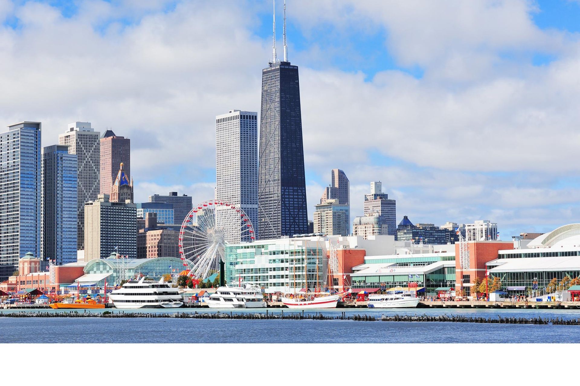 Chicago skyline with Ferris wheel, boats, and tall skyscrapers under a blue sky.