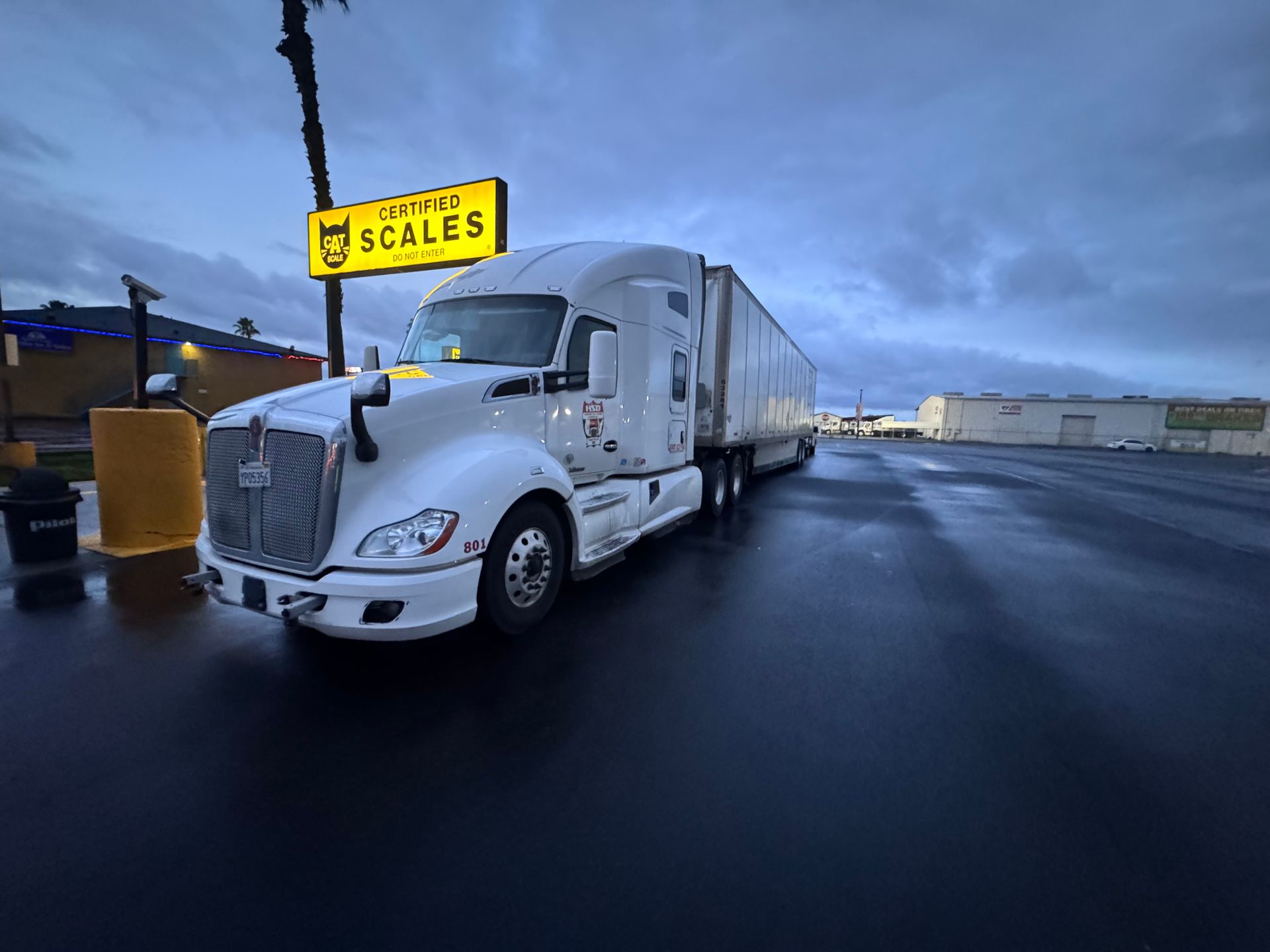 White semi-truck parked near a yellow 