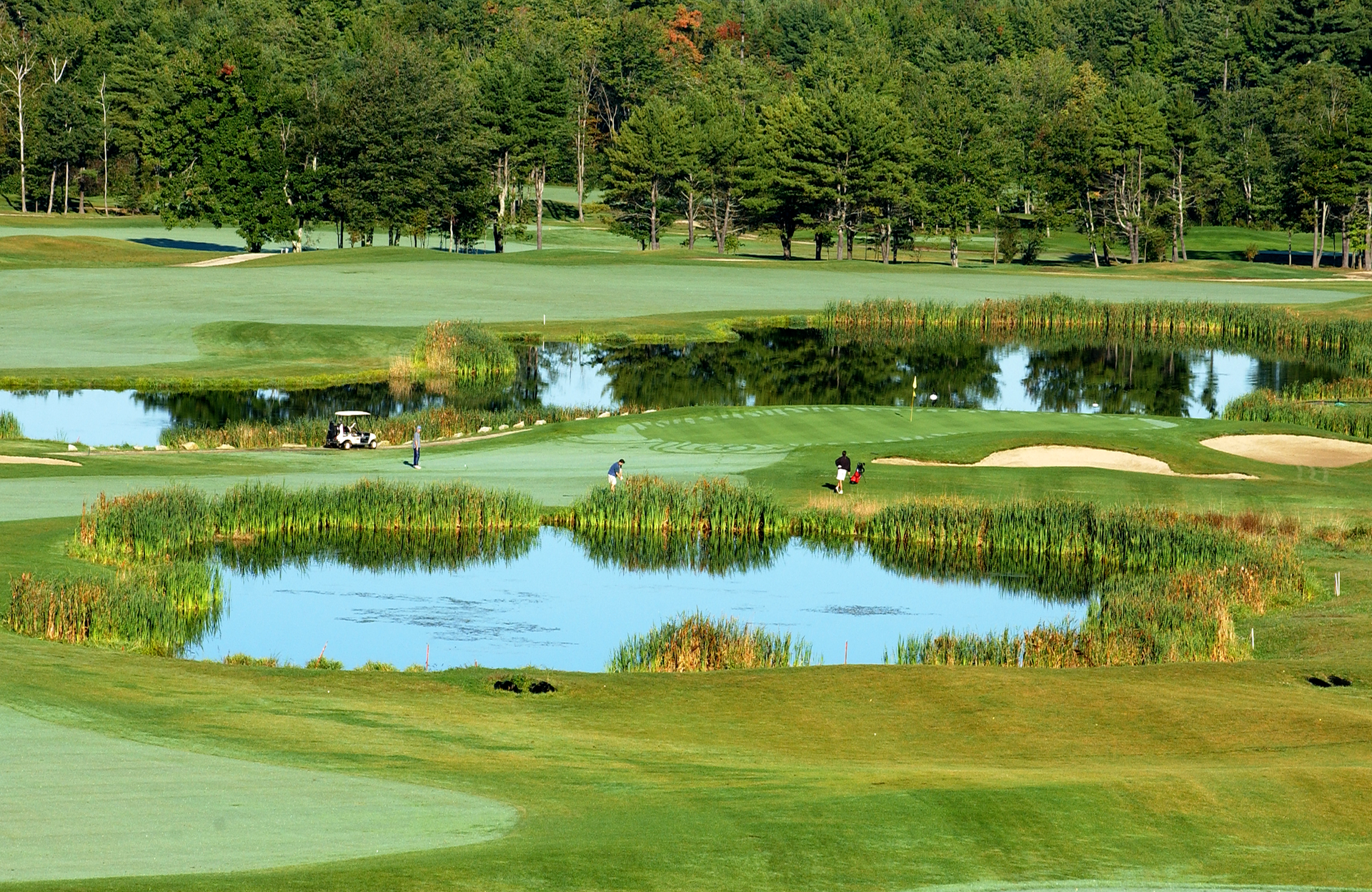 A golf course with a few ponds in the middle of it