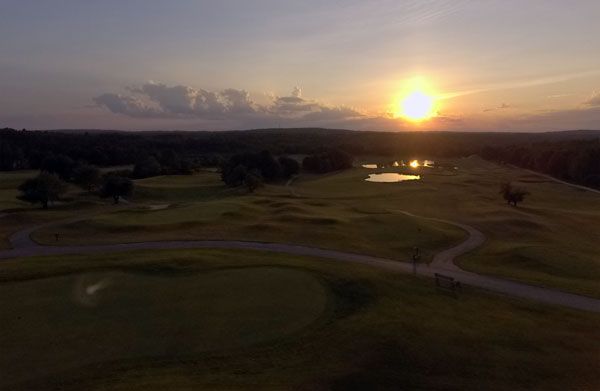An aerial view of a golf course at sunset.