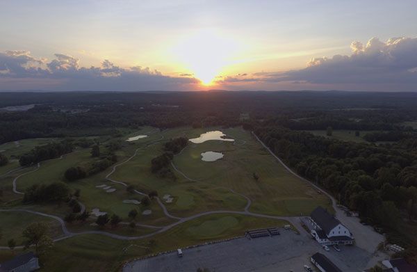 An aerial view of a golf course at sunset.