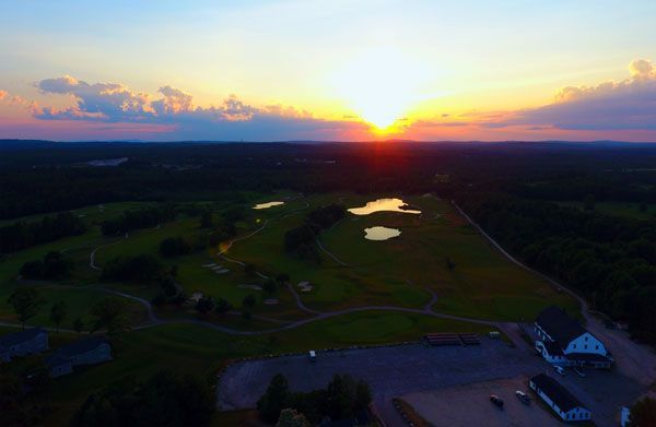 An aerial view of a golf course at sunset.