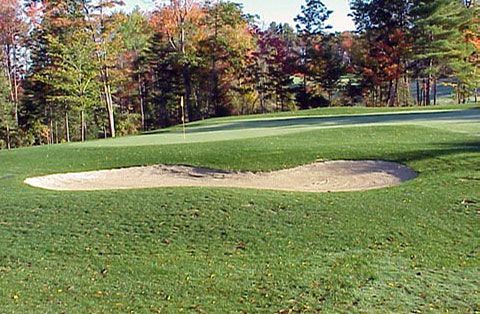 A golf course with a bunker in the middle of it