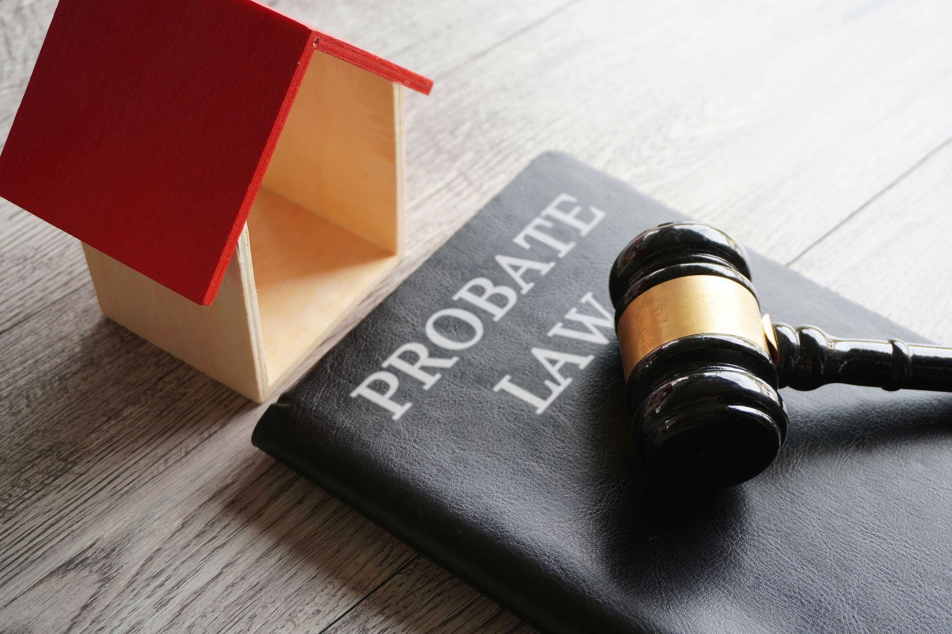 Toy house, gavel, and notebook with the text 