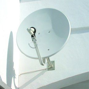 white satellite dish on side of a white wall