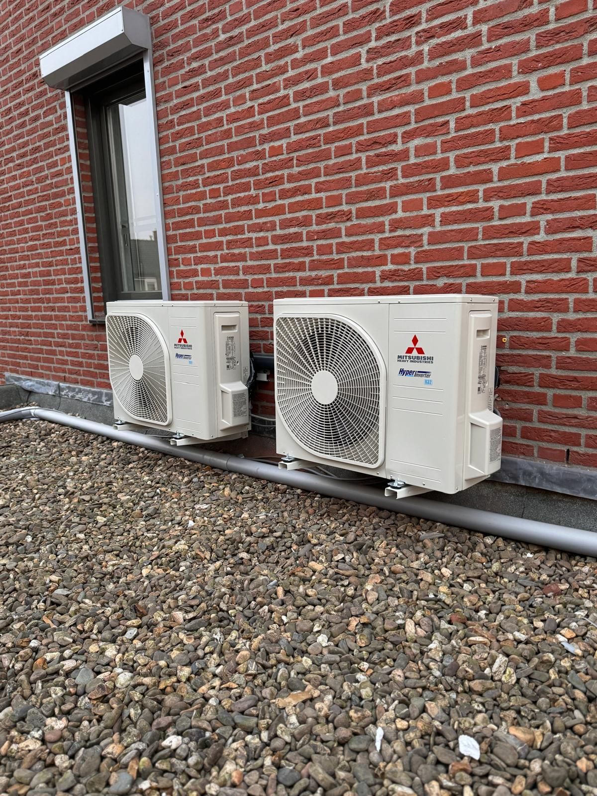 Twee Mitsubishi buitenunits voor airconditioning en verwarming