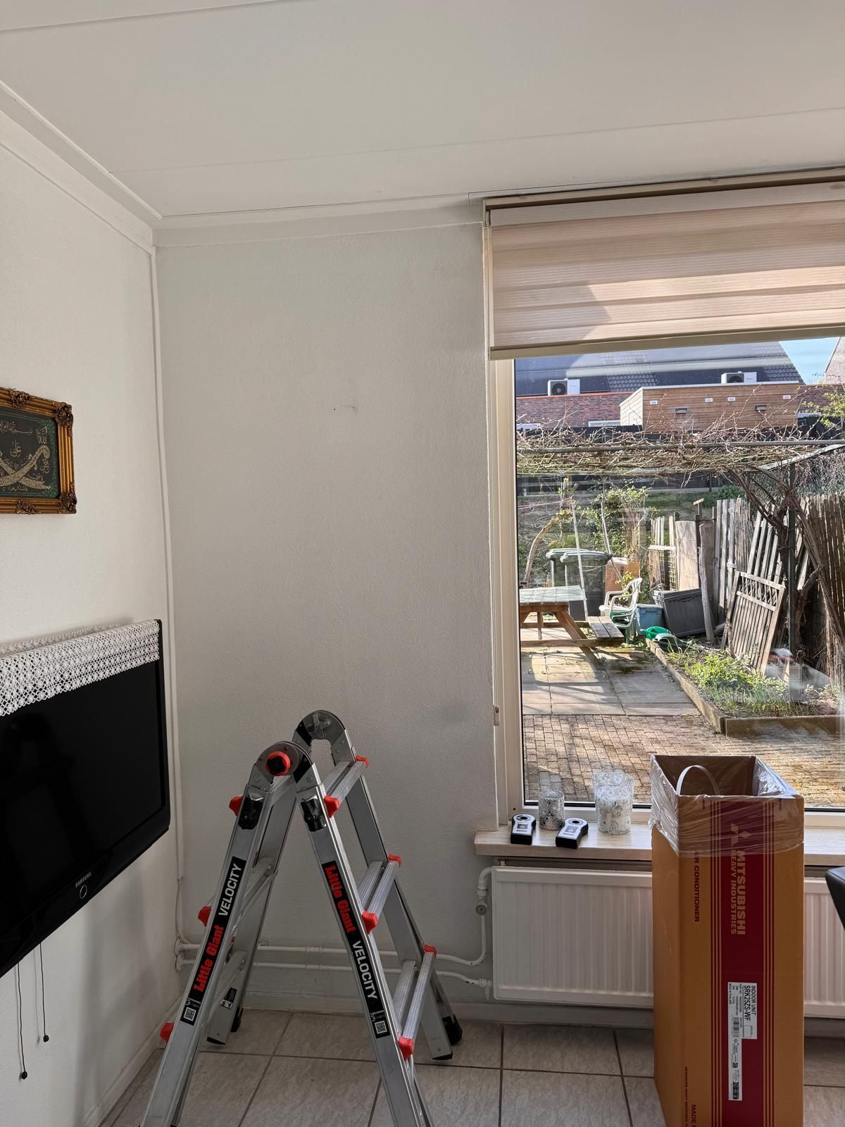Een kamer die gerenoveerd wordt, met een ladder, een aan de muur