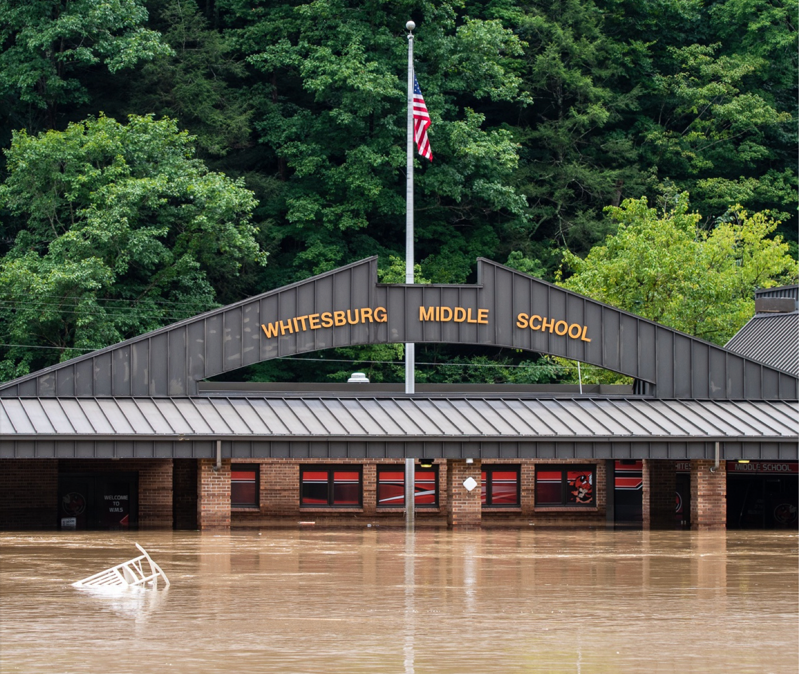 A flooded whitesburg middle school with trees in the background