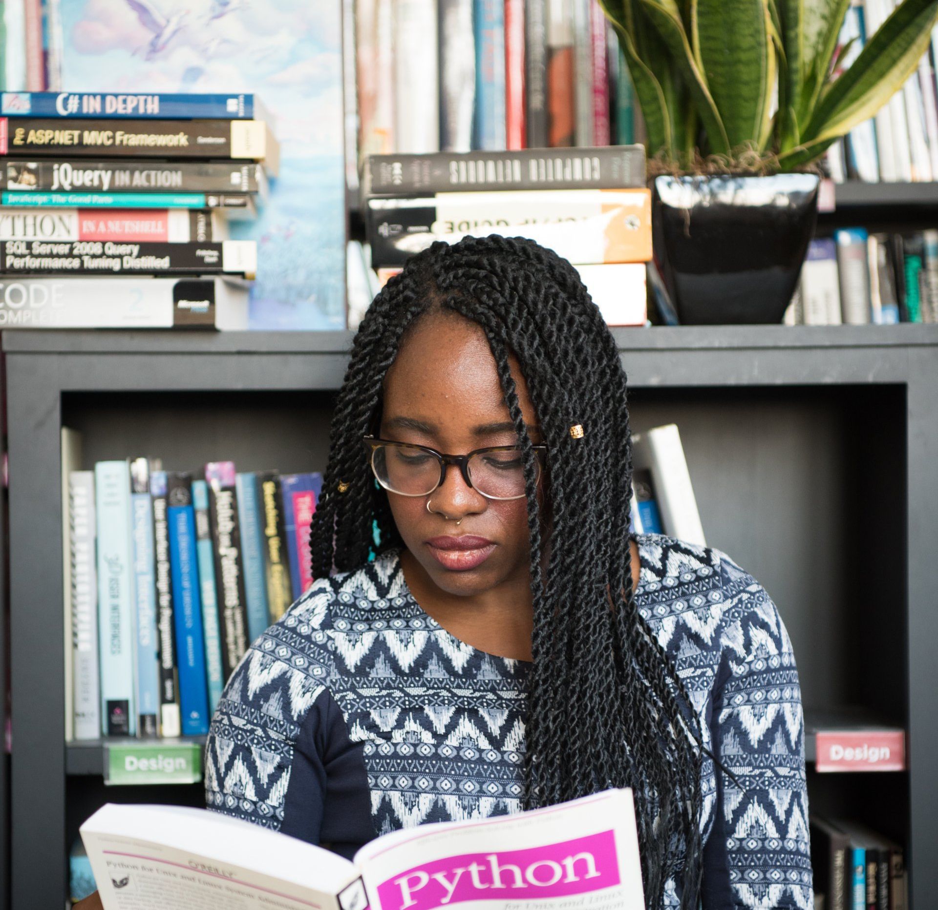 A woman is reading a book titled python