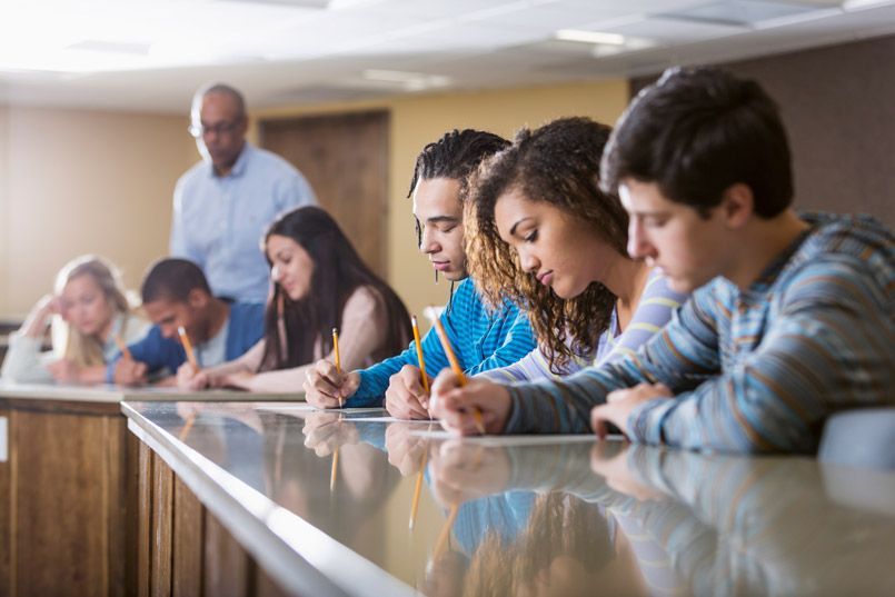 A group of students are taking a test in a classroom.