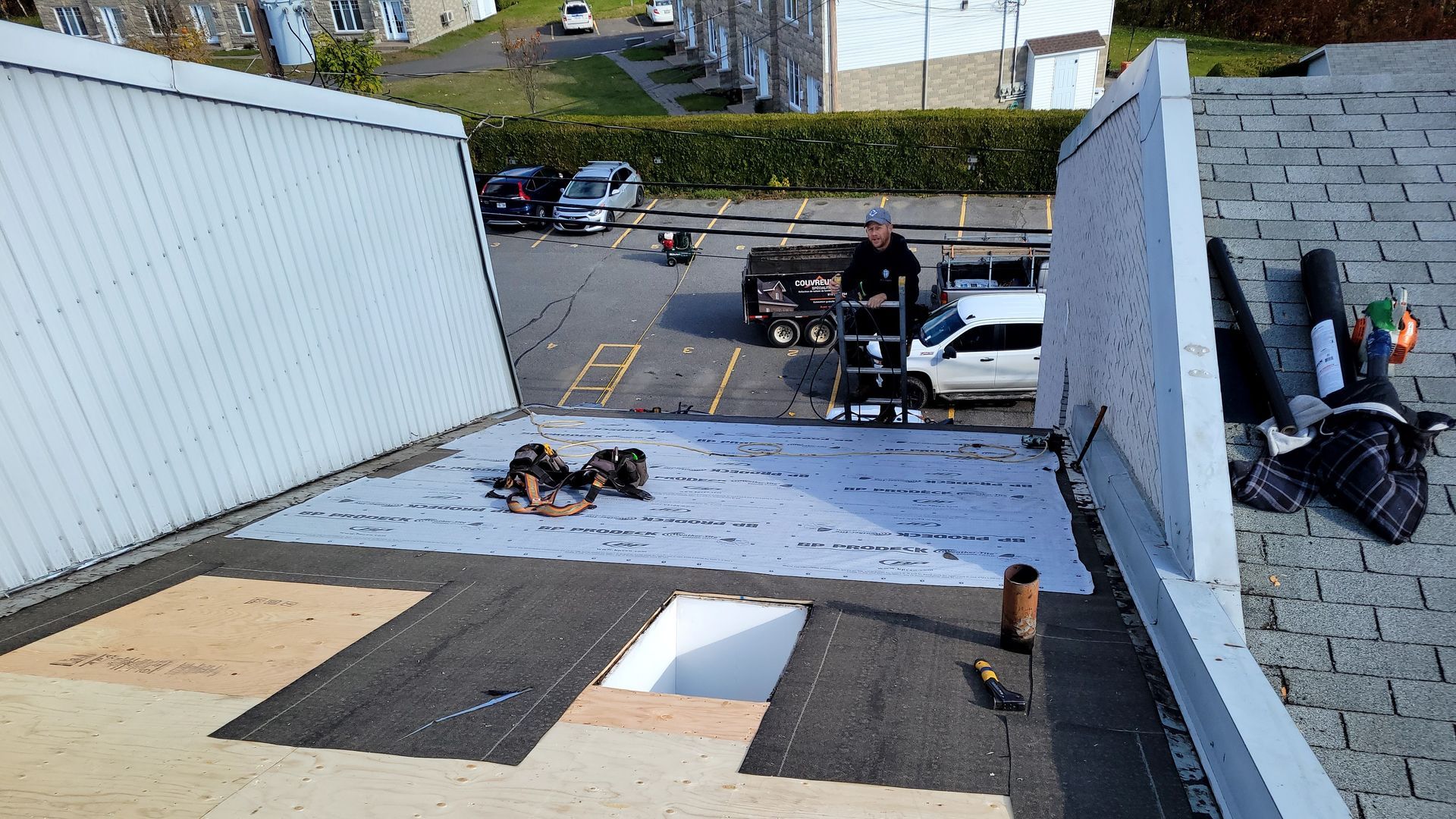 Un toit est en cours d'installation sur un bâtiment dans un parking.