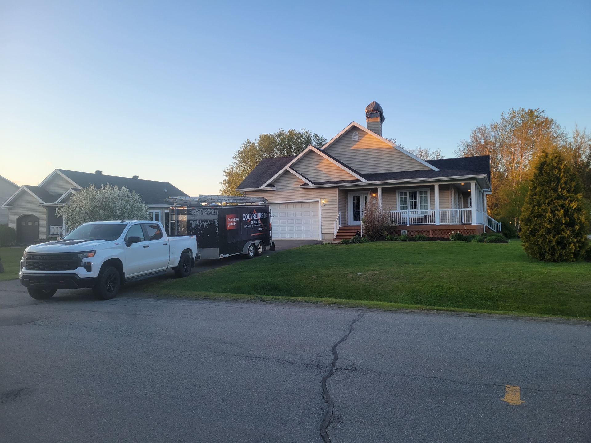 Un camion blanc est garé devant une maison.