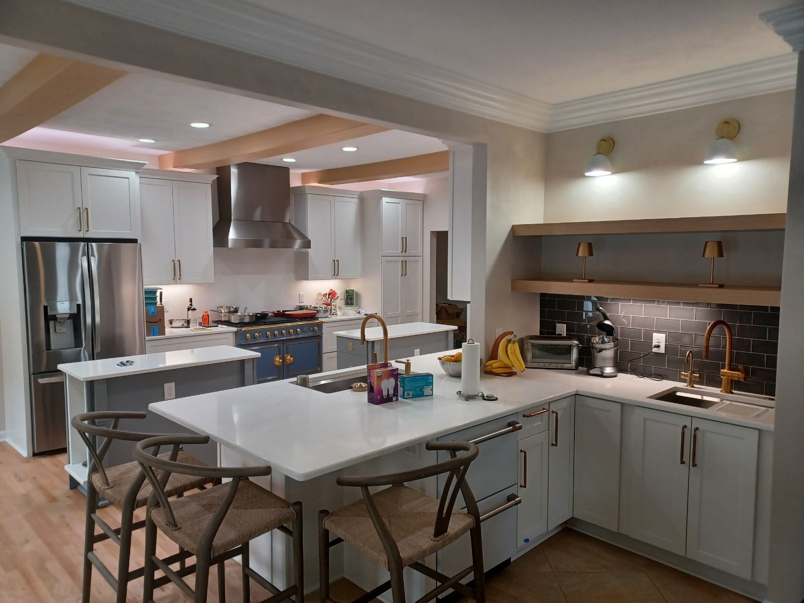 A kitchen with white cabinets , stainless steel appliances , and a large island.