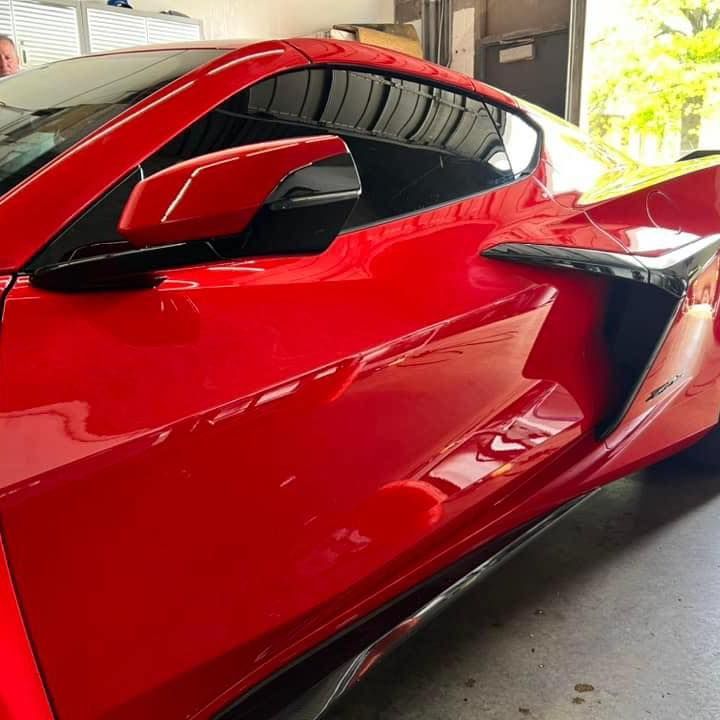 A red sports car is parked in a garage