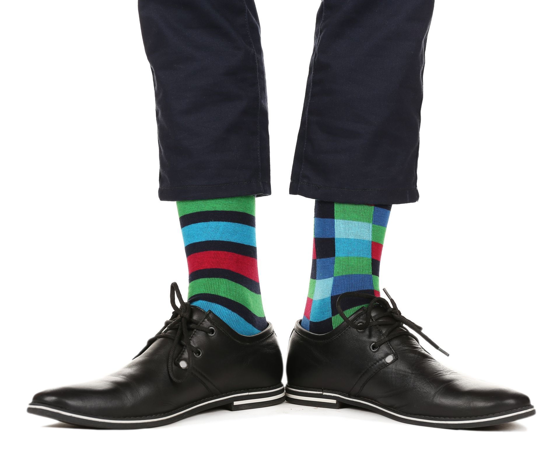 (Fashion Show and Tell) A man lifts his trousers to display mismatched socks and smart business shoes.