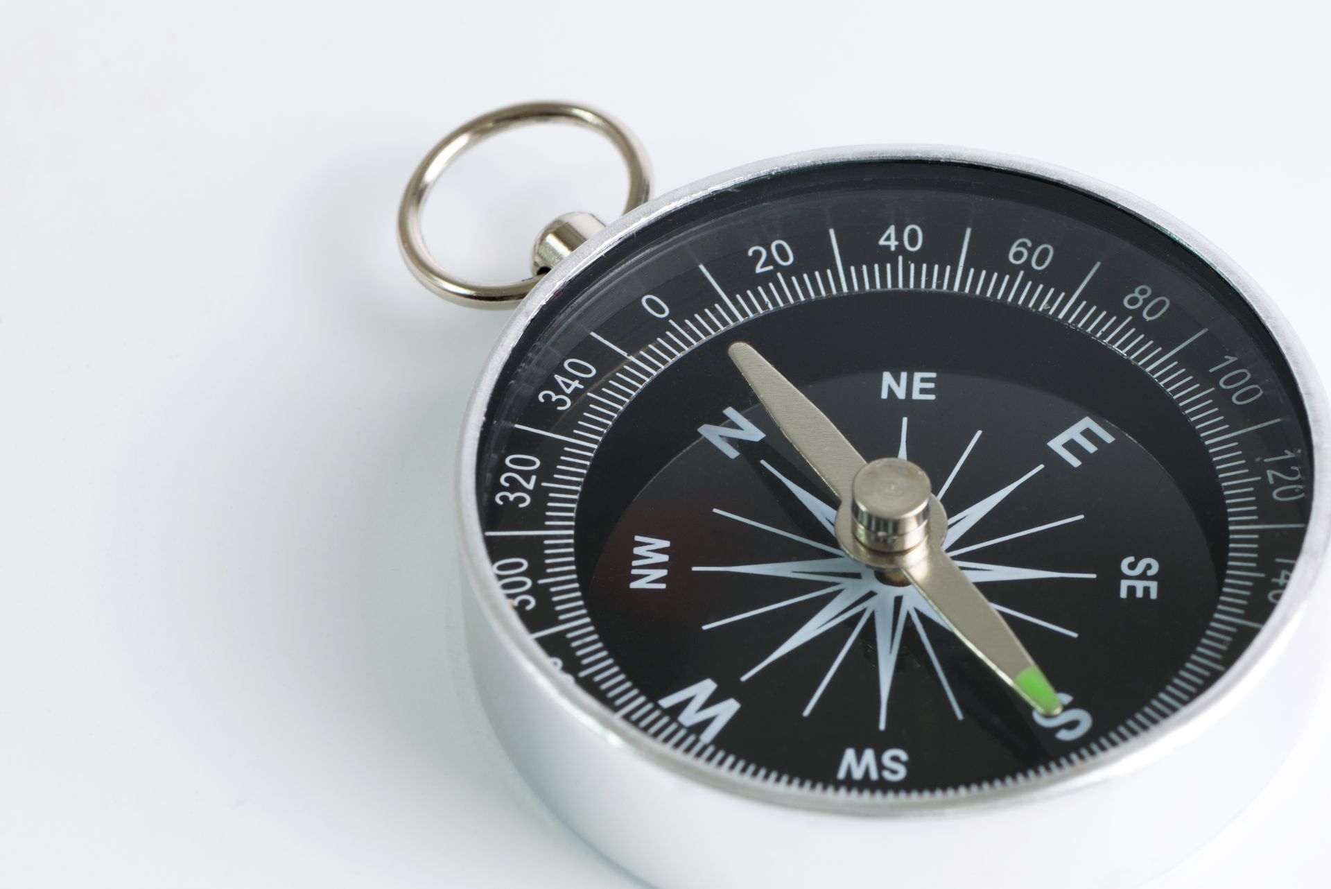 (GPS Guru) A simple, metal compass with its travel arrow pointing to South.