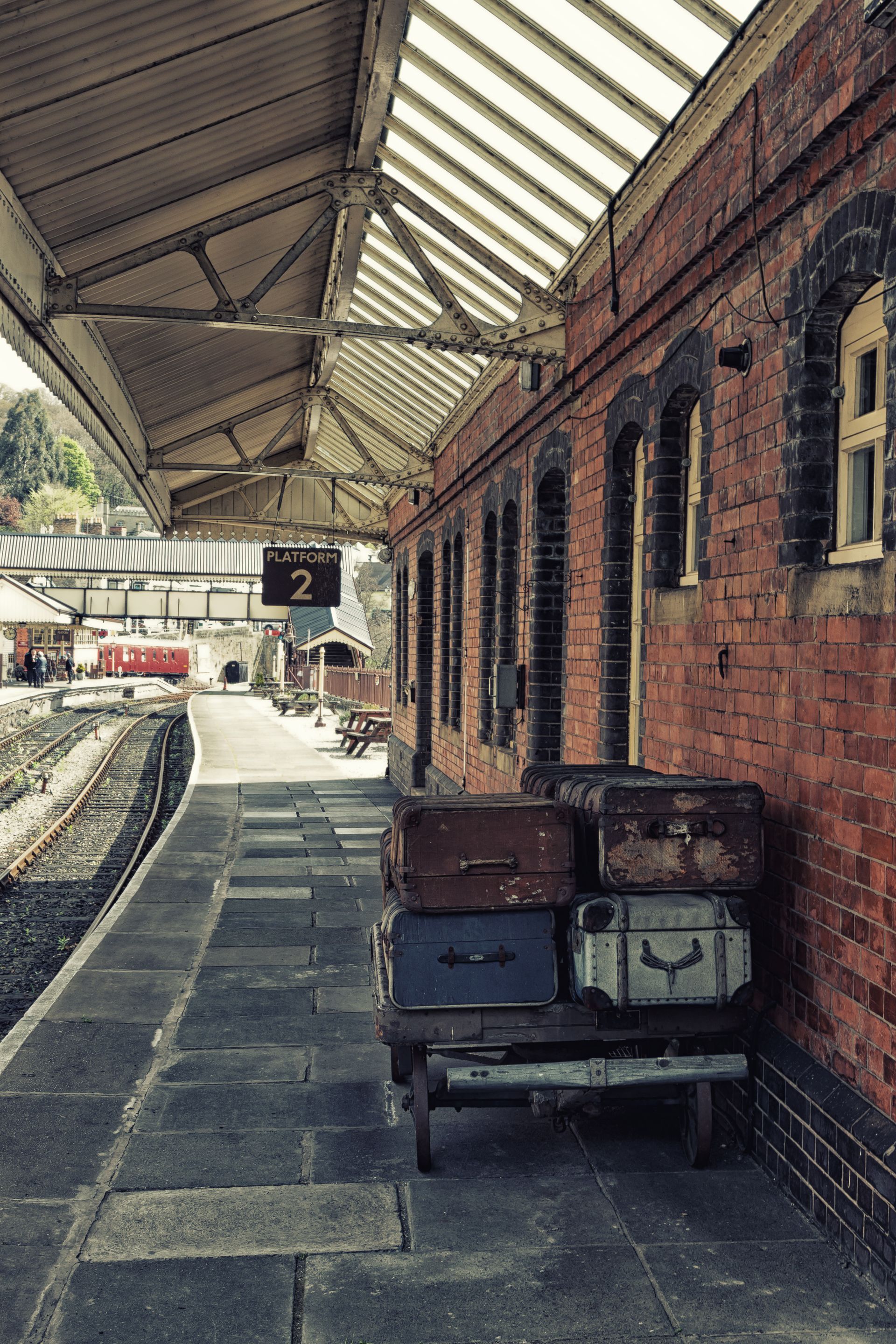 An older railway platform in Wales. The walkway is made of uneven paving stones.