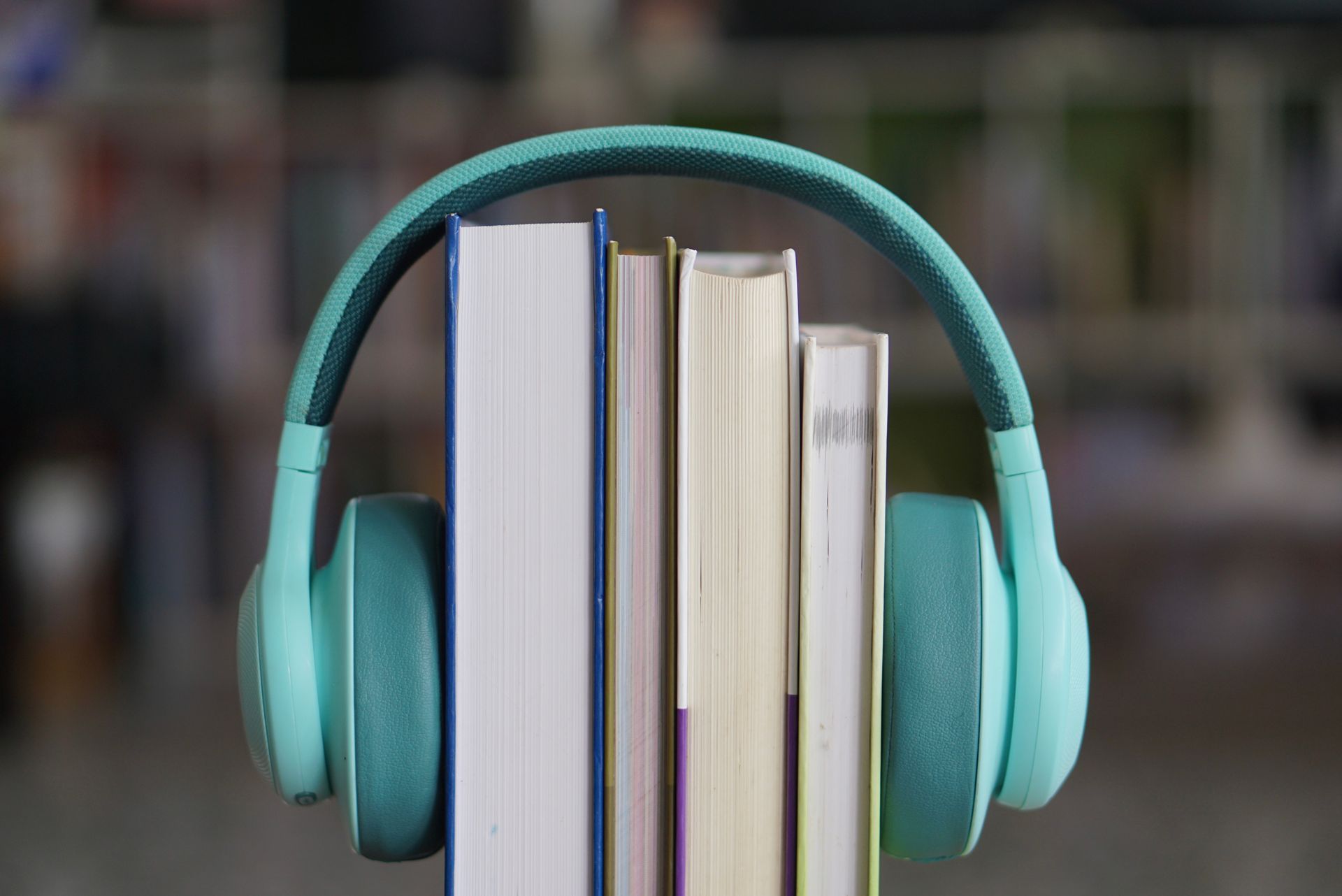 A set of headphones rest over a collection of books to symbolise audiobooks.