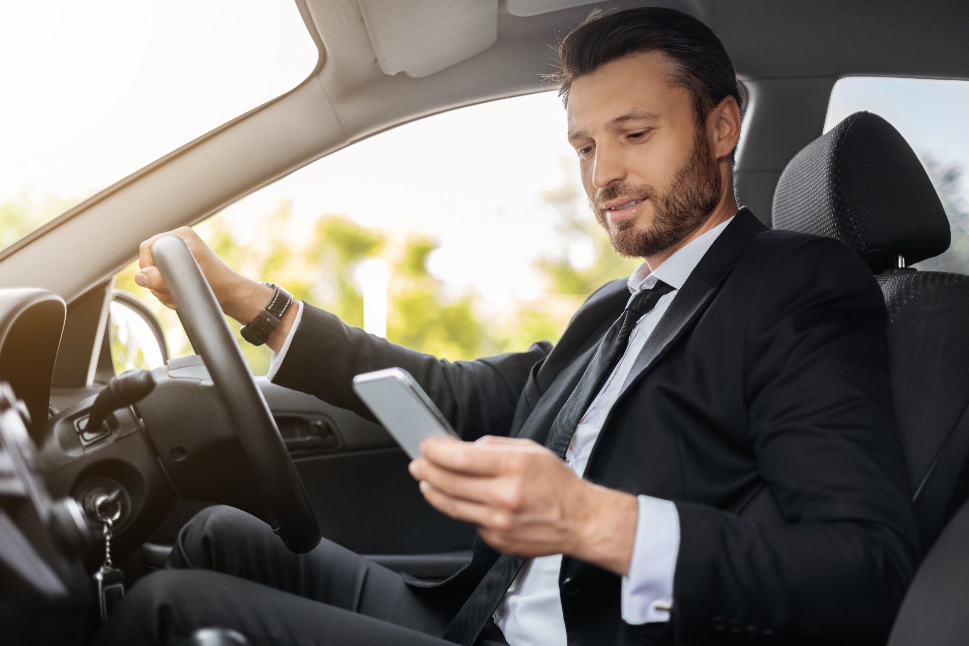 A businessman texting on the phone whilst driving.