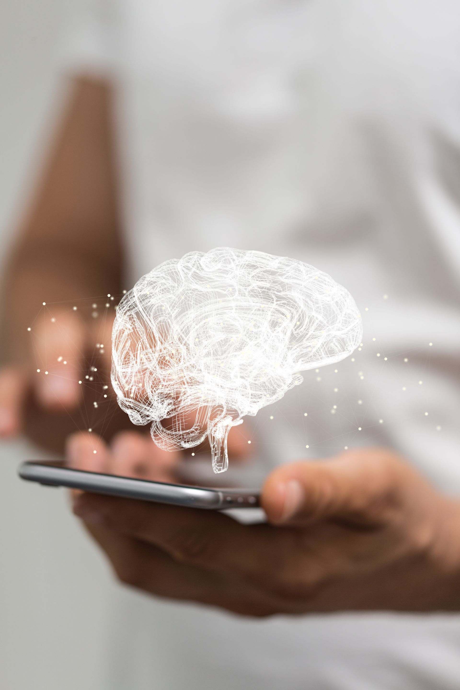 A woman scrolls through her phone, an illustrated and heavy stylised brain hovering above the device to symbolise artificial intelligence.