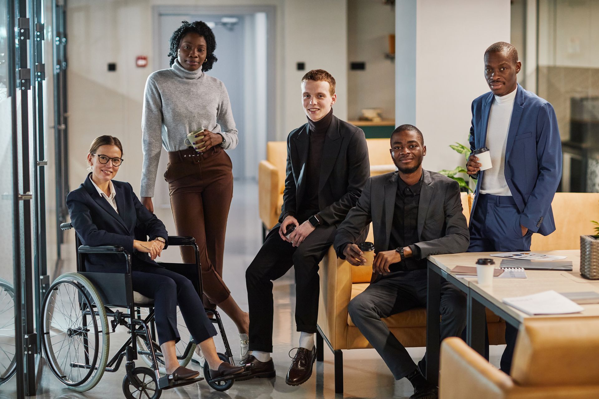 Full length portrait of diverse business team including young woman in a wheelchair.