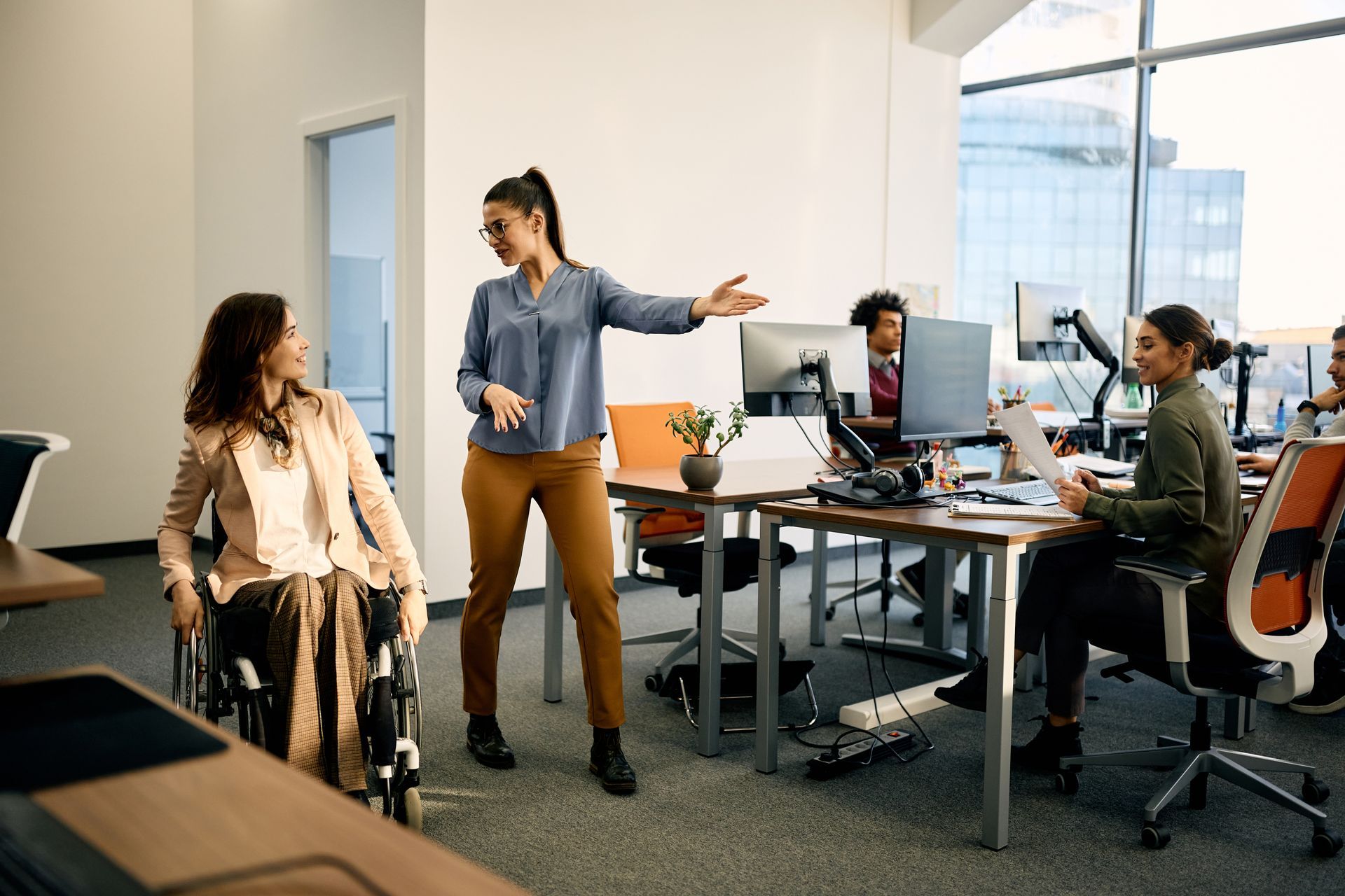 A young woman who uses a wheelchair is introduced into an office environment.