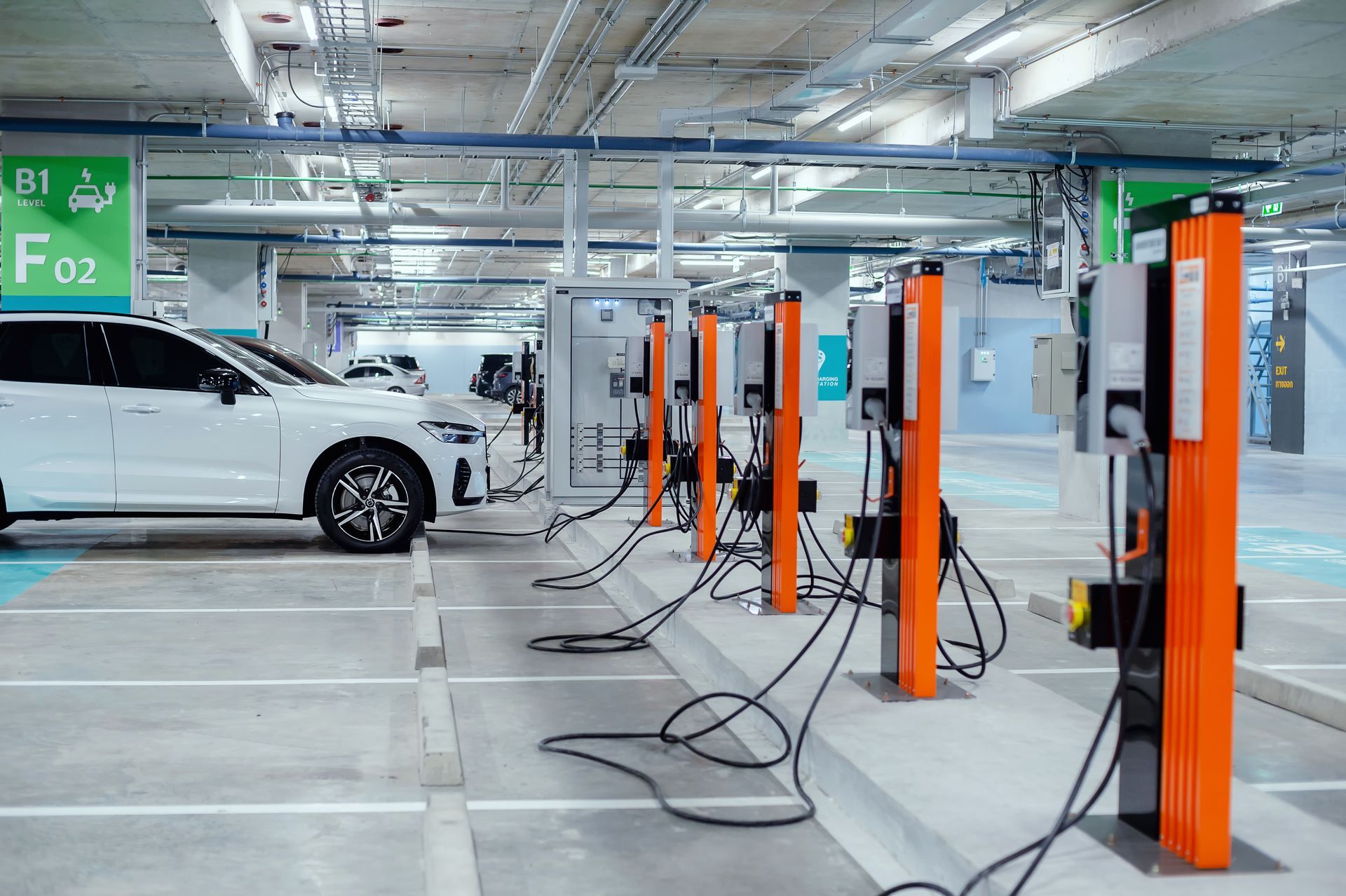 Photo of an indoor EV charging station. A raised concrete lip prevents easy access to the charging stands.