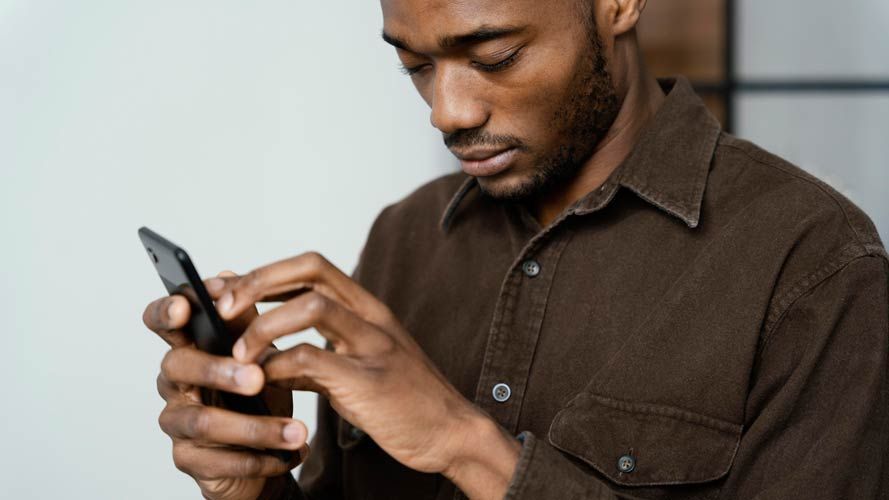 Visually impaired man using a mobile phone device