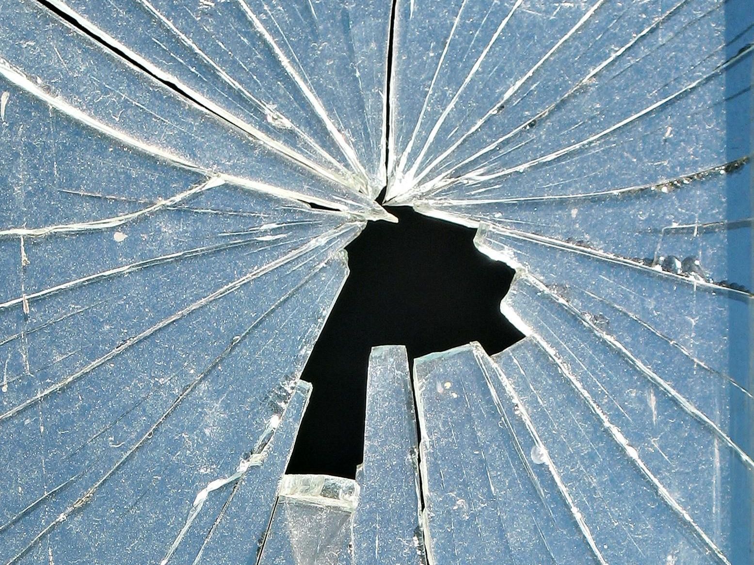 a close‑up view of shattered glass spidering from a central break point, reflecting the fragility of trust when it fails