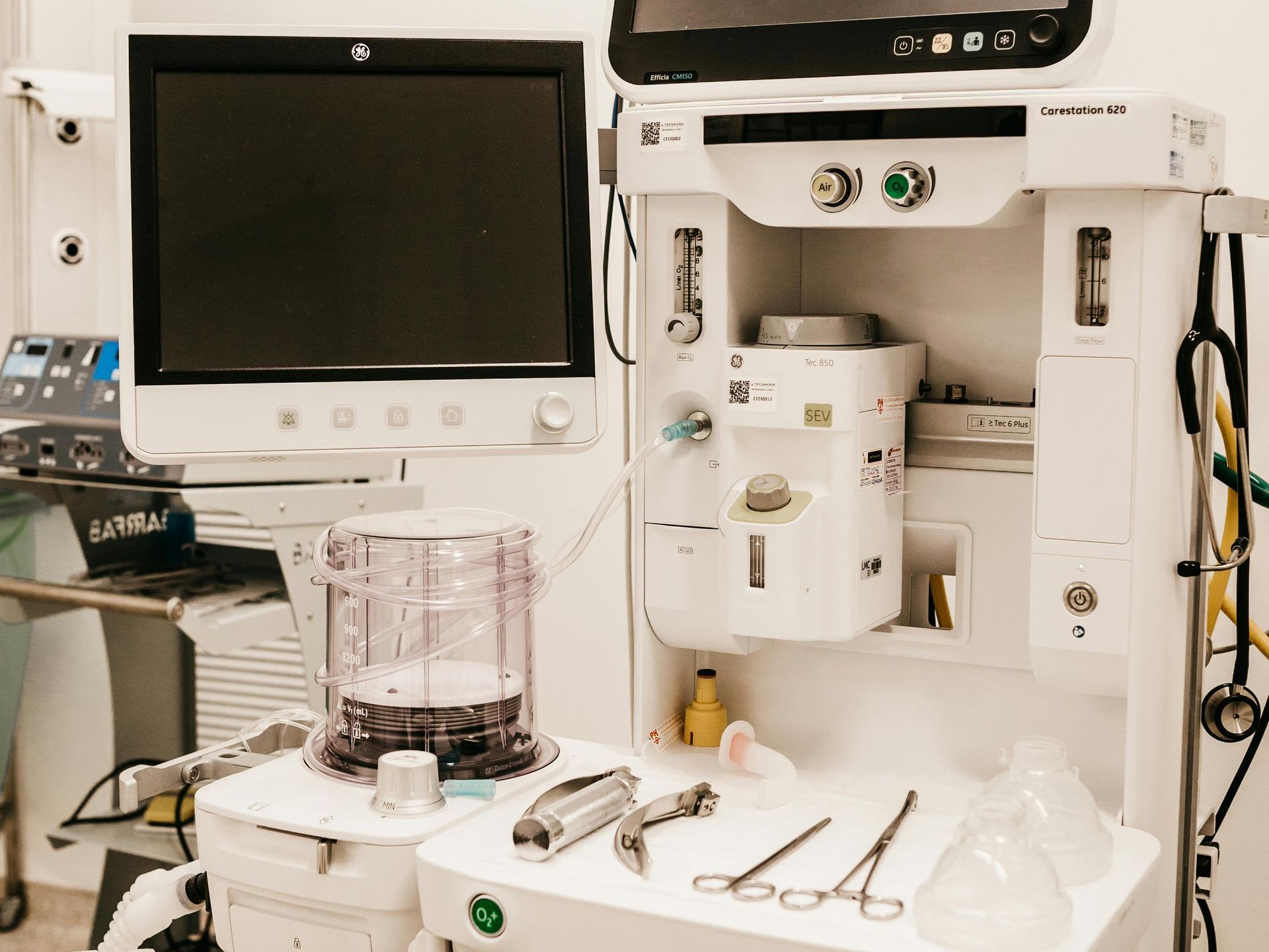 a row of high‑tech hospital monitors and equipment in a clinical room, each screen displaying vital signs and data—symbols of precision, reliability and the quiet reassurance technology can bring