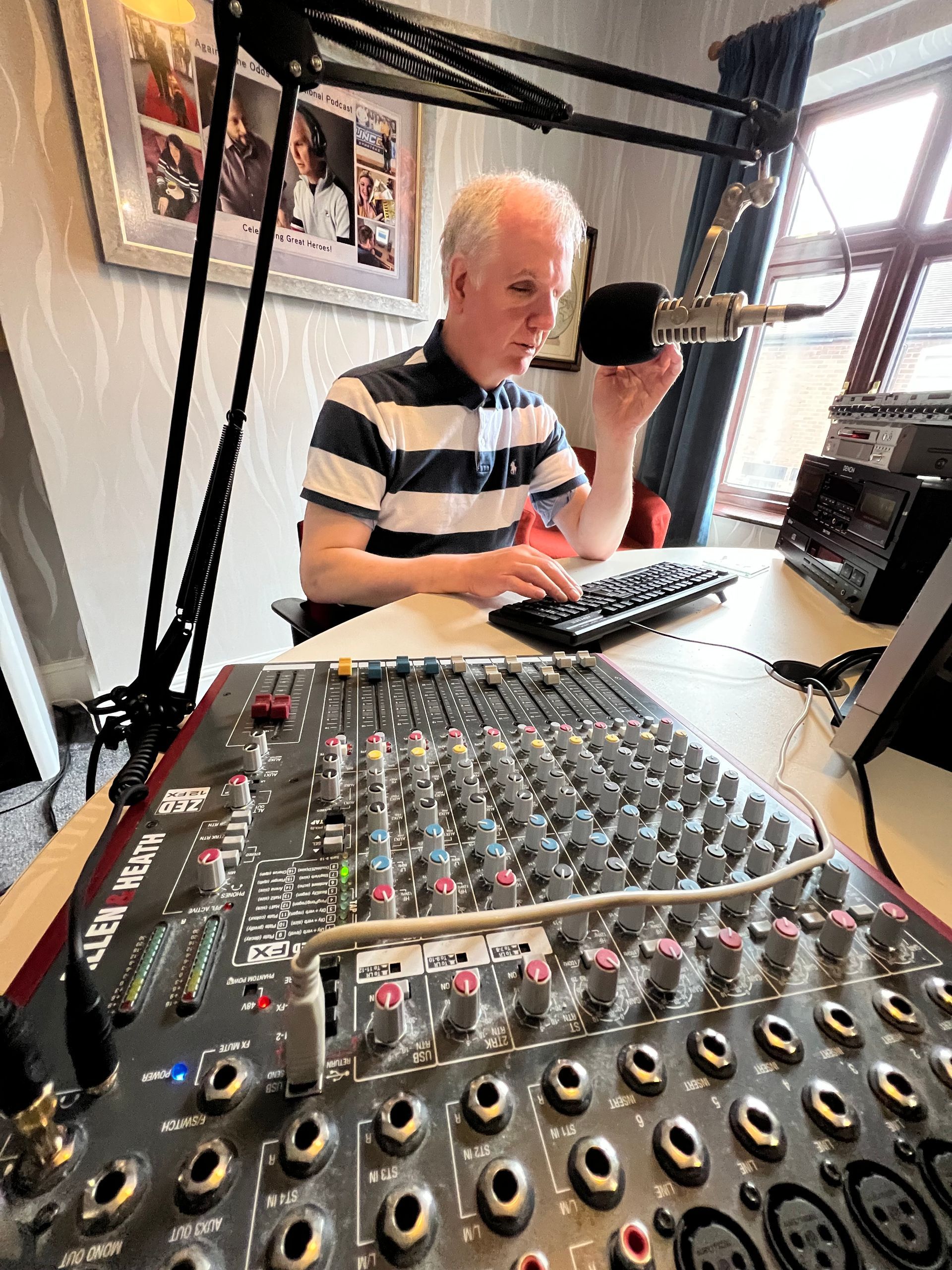 Philip Anderson records a podcast, his recording desk front and centre.