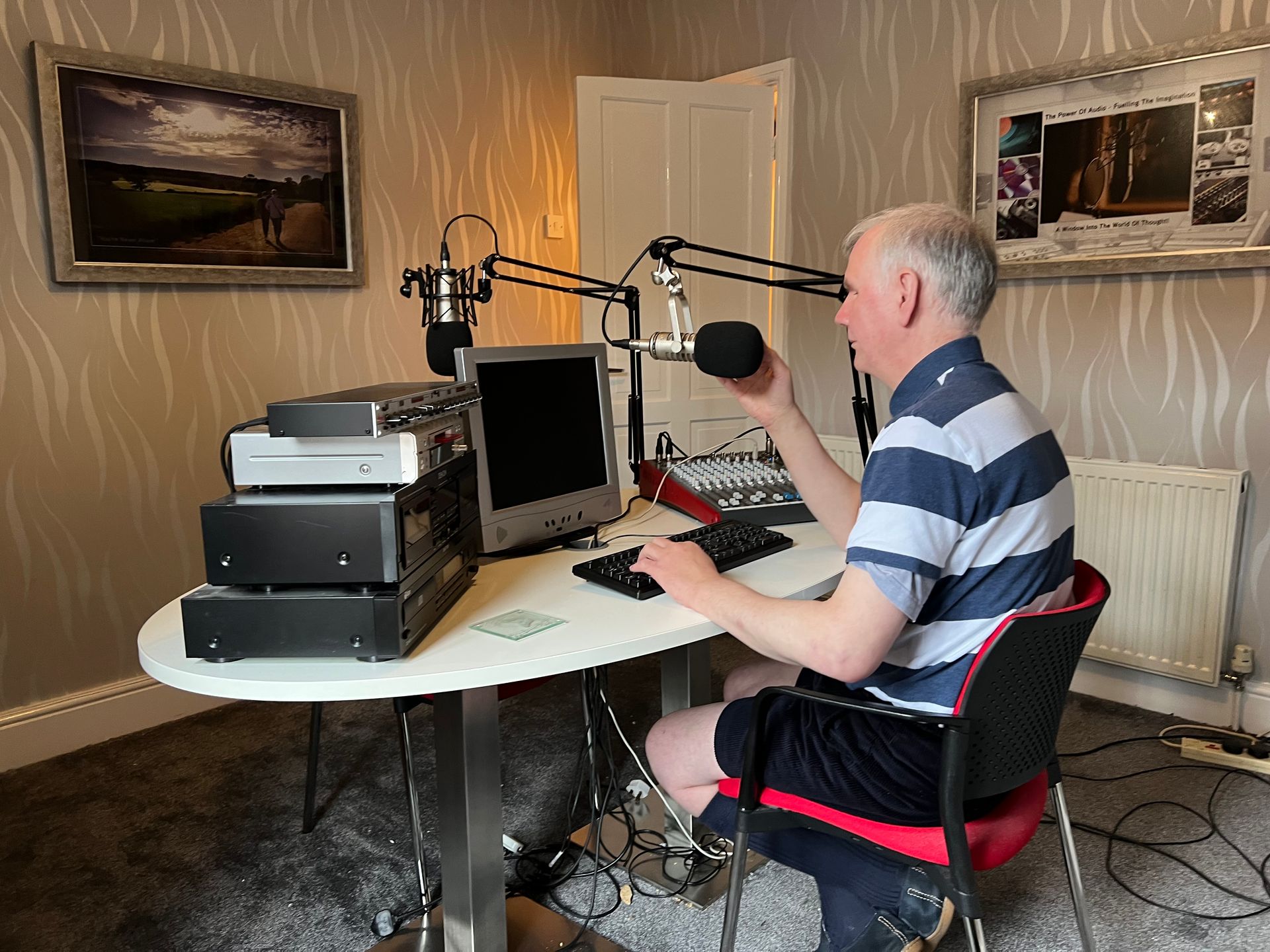 Philip Anderson in his study, using his computer and recording equipment.