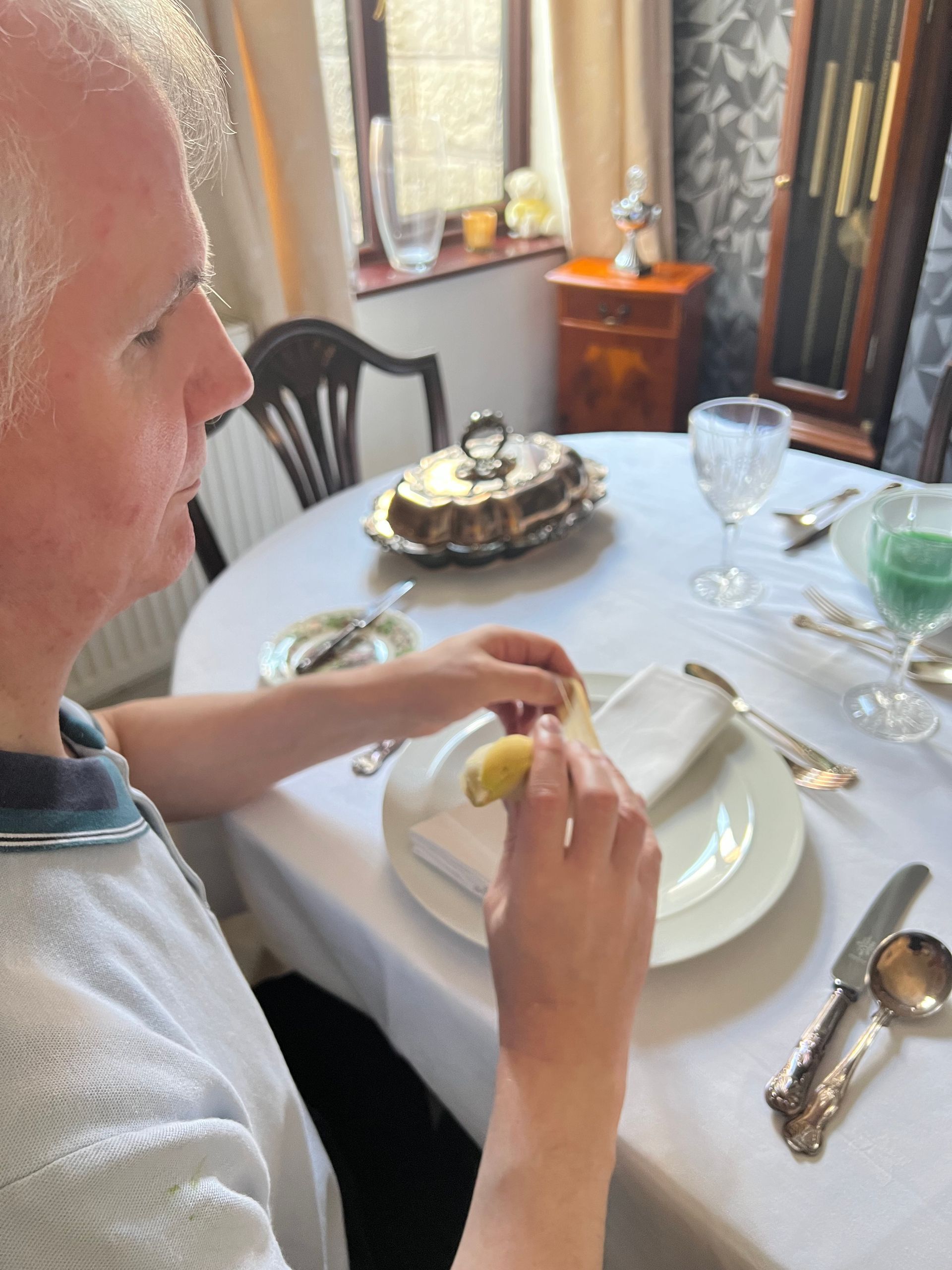 Philip Anderson peels a banana at his neat dining table.
