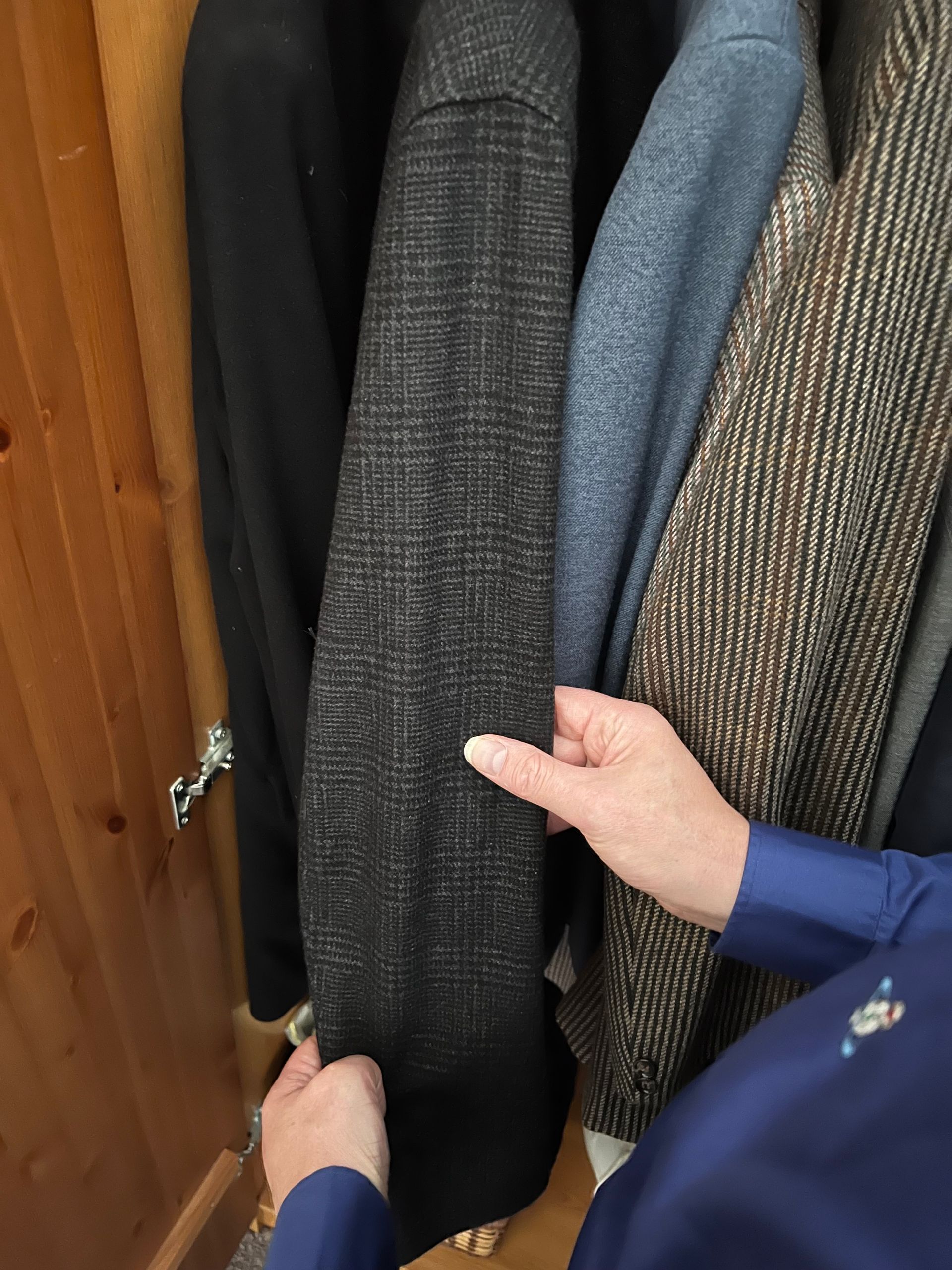 Philip Anderson feeling the texture of a woolen jacket.