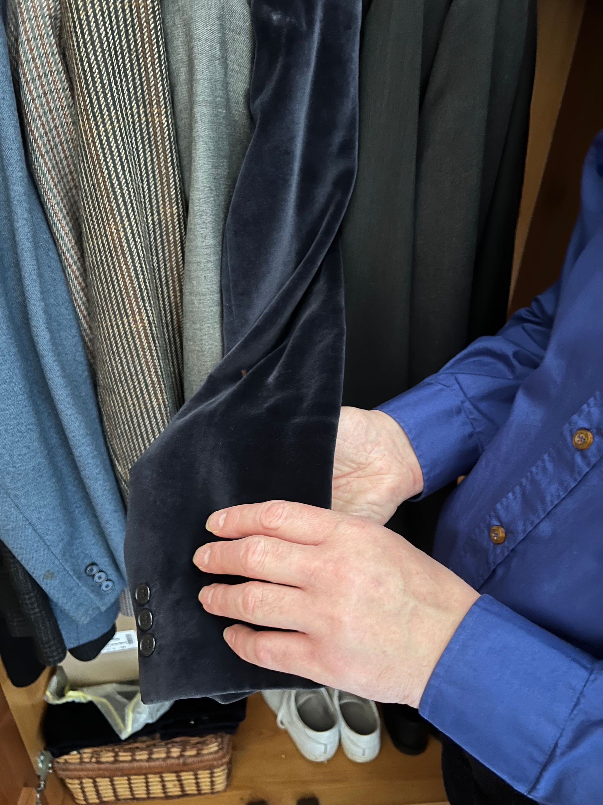 Philip Anderson feeling the texture of a velvet acket.