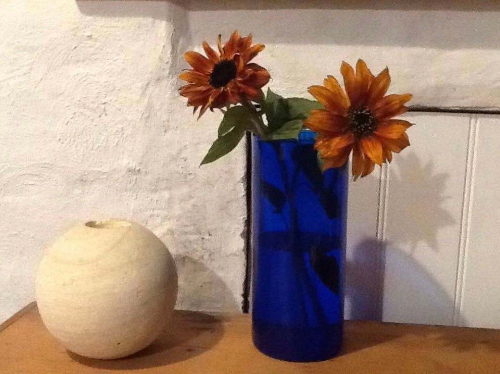 Two Sunflowers in a blue glass vase