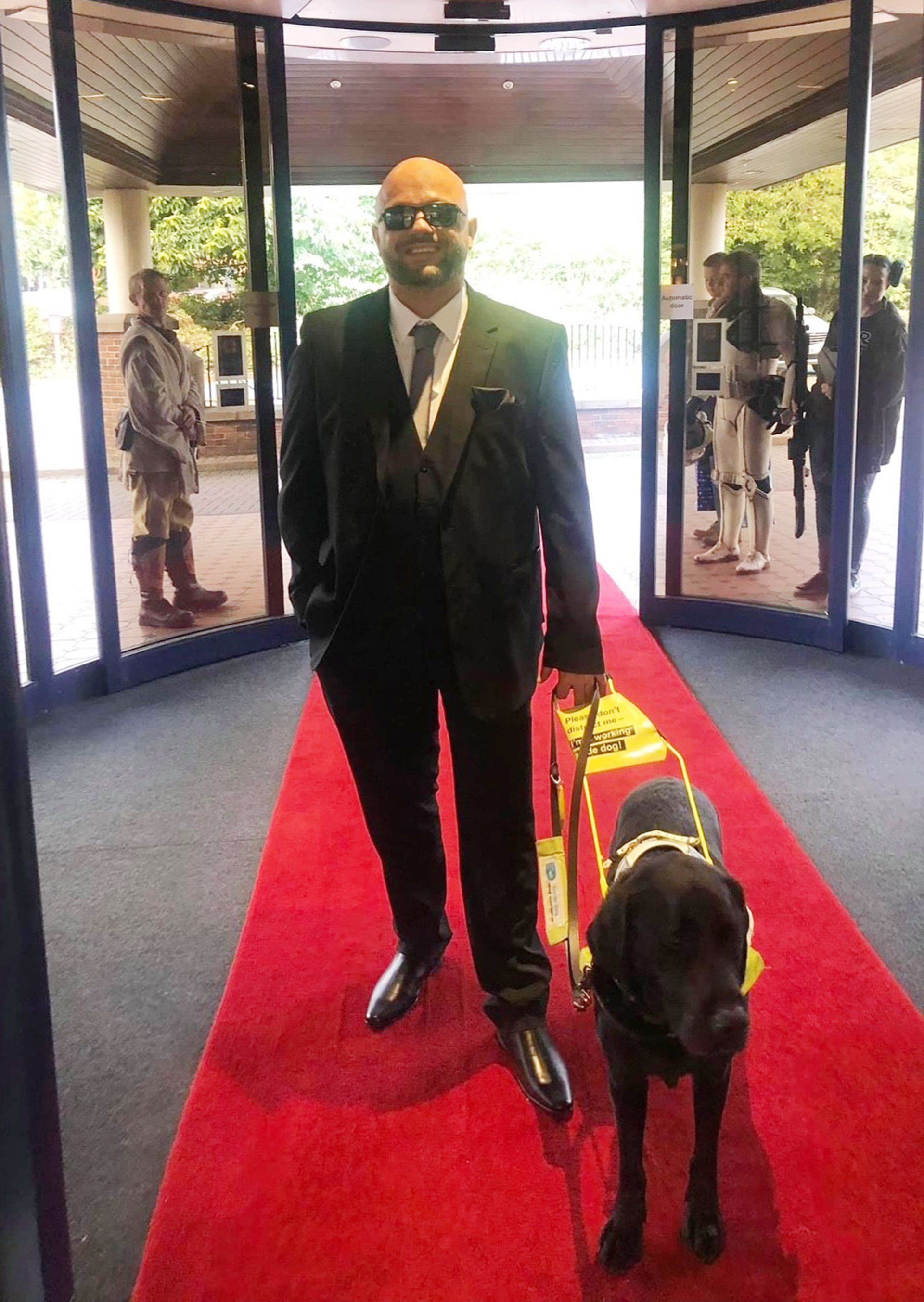 Wayne Pugh posing with his guide dog Vince on the red carpet for Our Staffordshire Heroes Awards