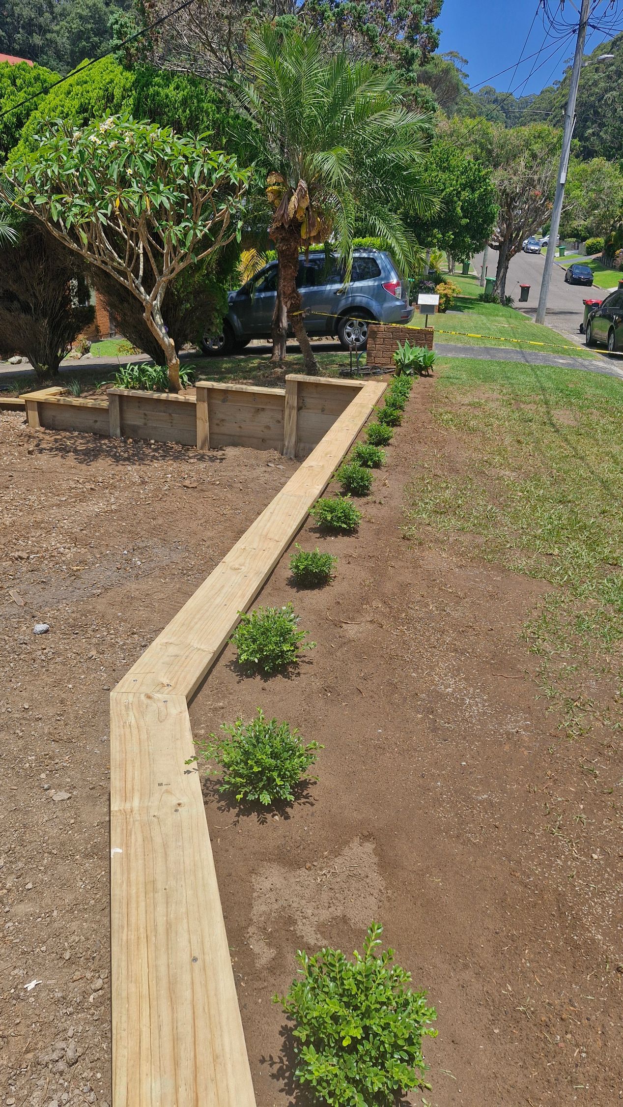 A Metal Fence Surrounds a Swimming Pool With Trees in the Background — Strike Fencing & Gates in Wamberal, NSW