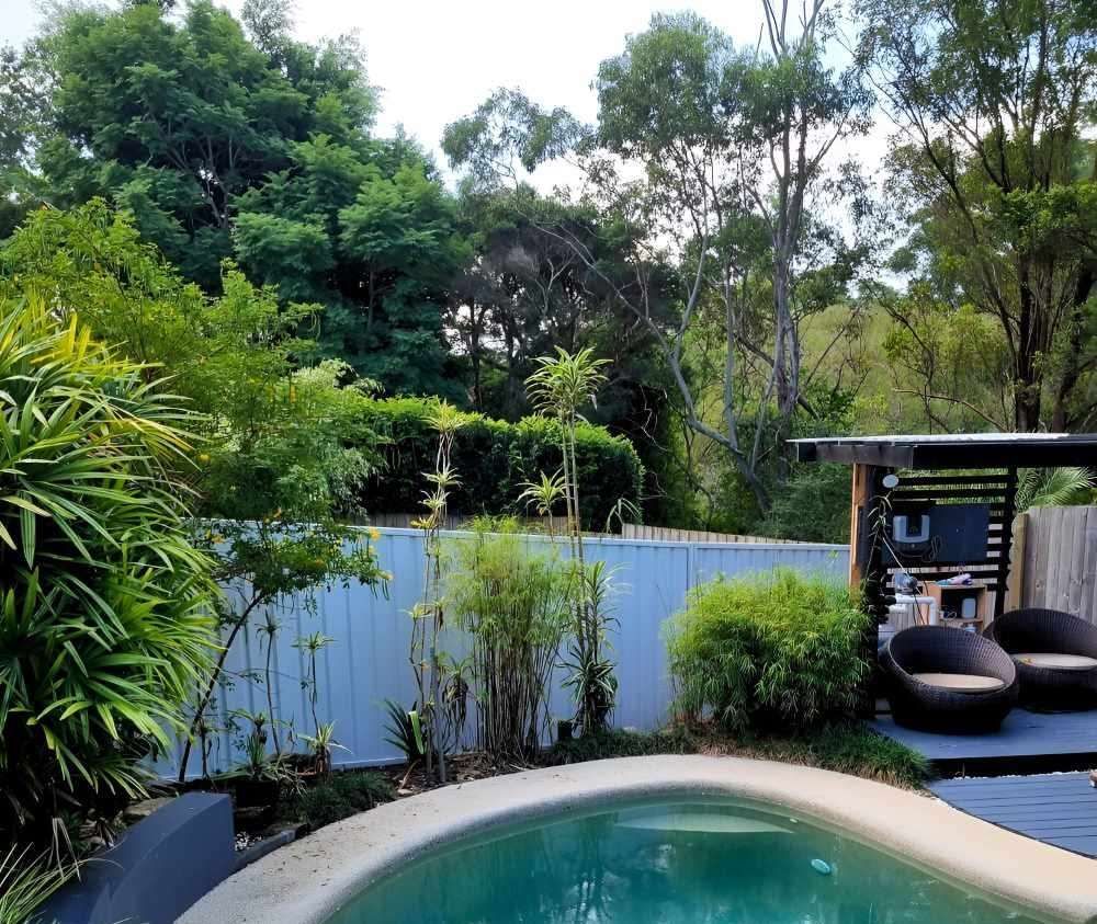 A Swimming Pool in a Backyard Surrounded by Trees — Strike Fencing & Gates in Terrigal, NSW