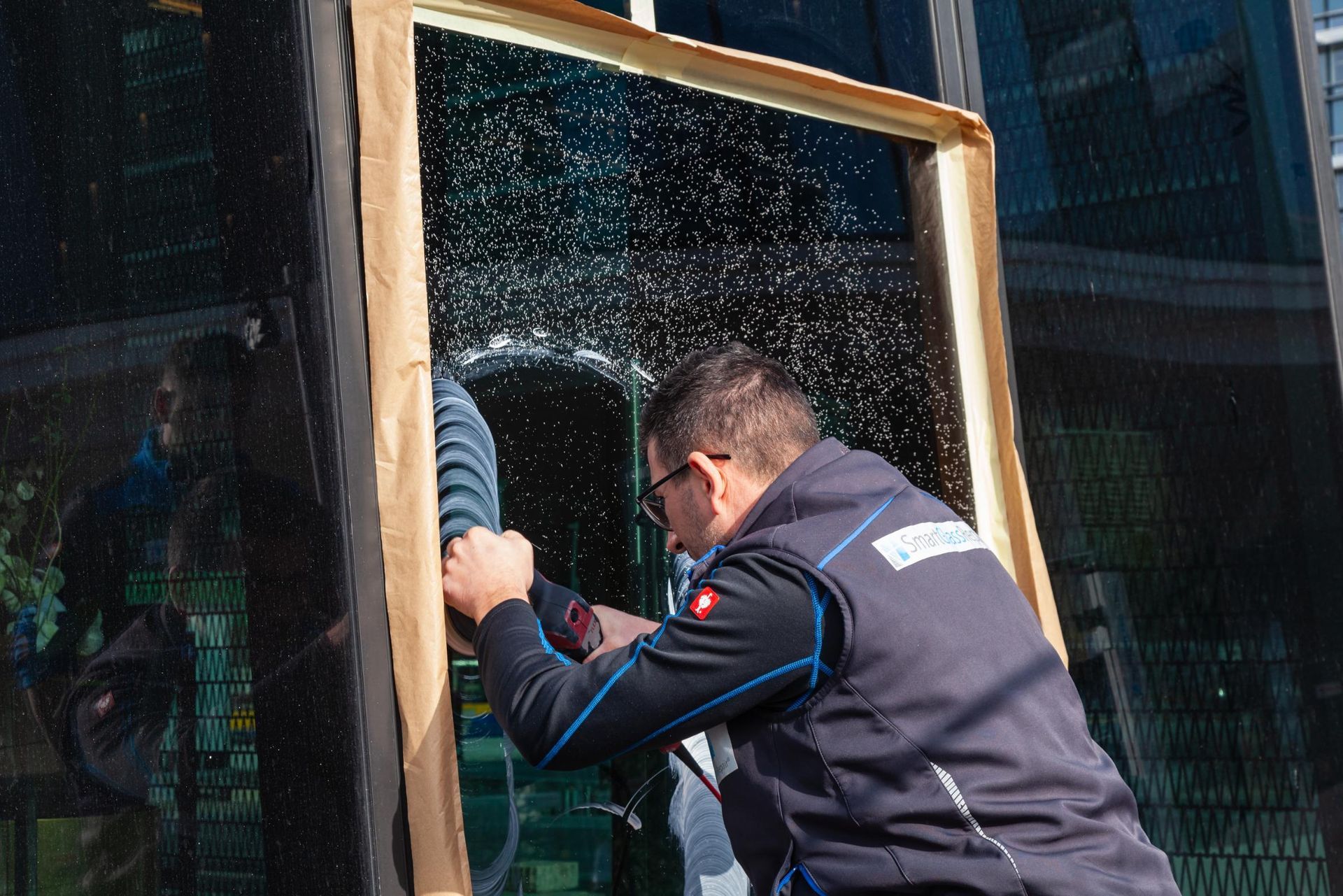 Ein Mann arbeitet mit einer Bohrmaschine an einem Fenster.