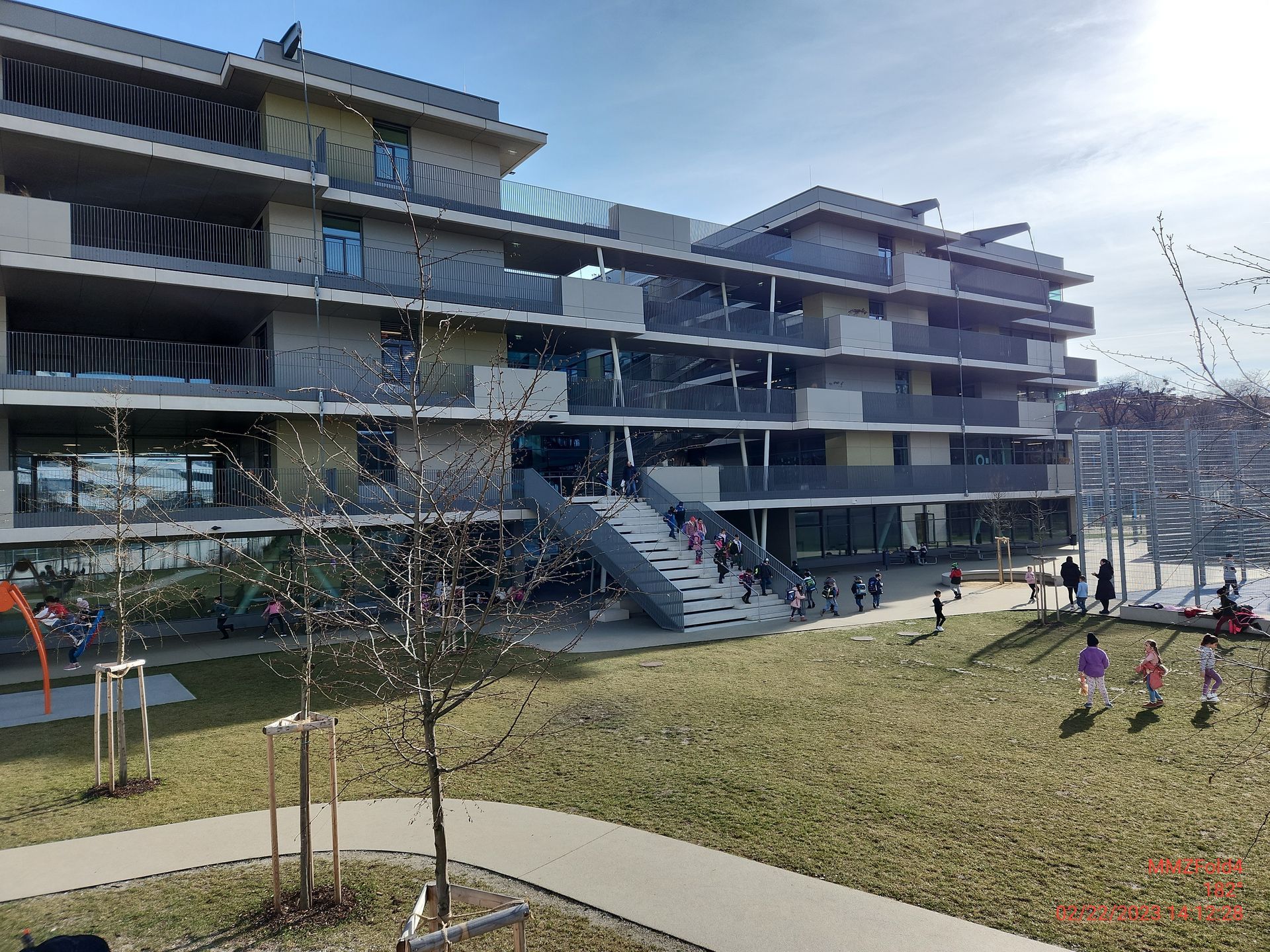 Eine Gruppe Kinder spielt vor einem großen Gebäude