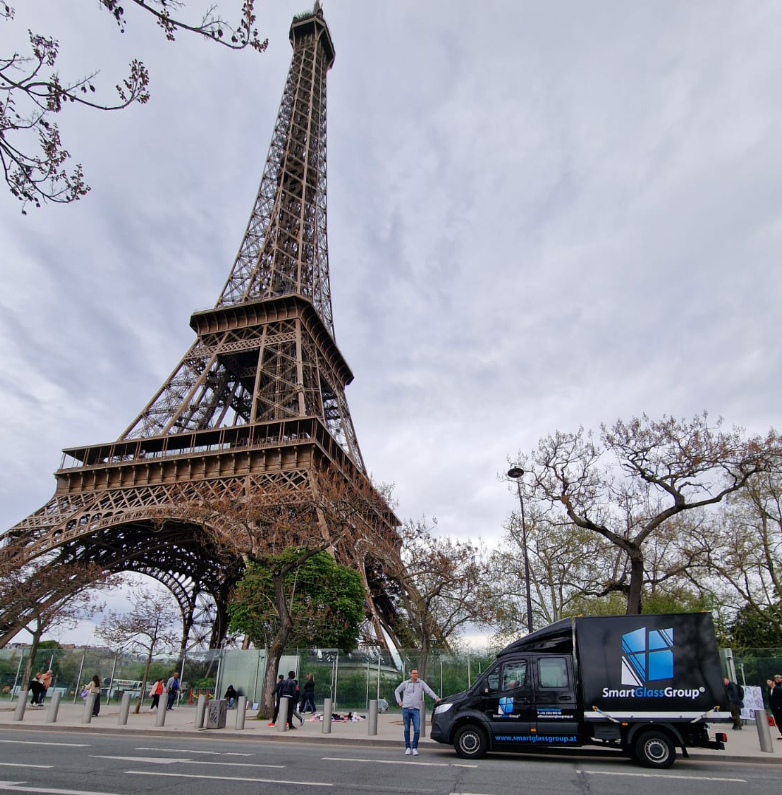 Ein Mann steht vor dem Eiffelturm