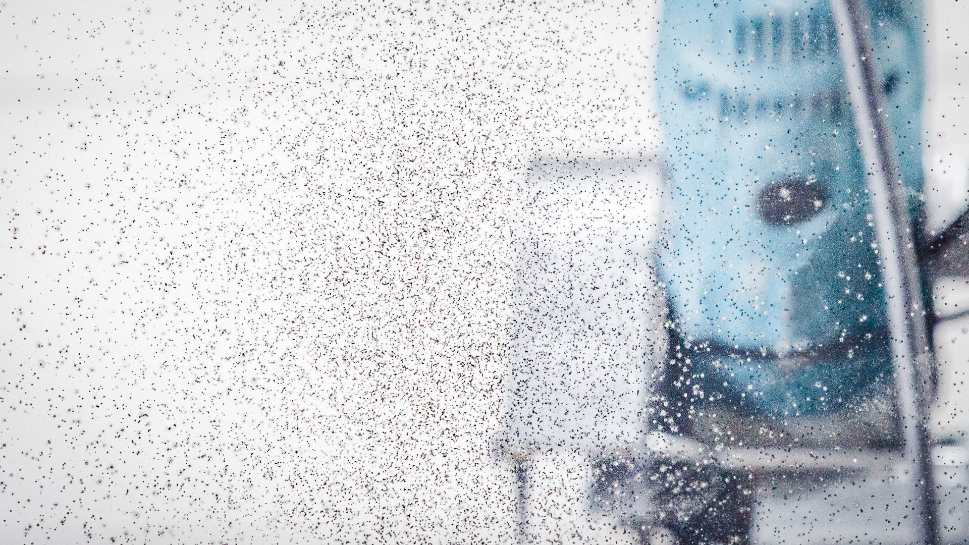 Eine Nahaufnahme eines Fensters, auf das Schnee fällt.