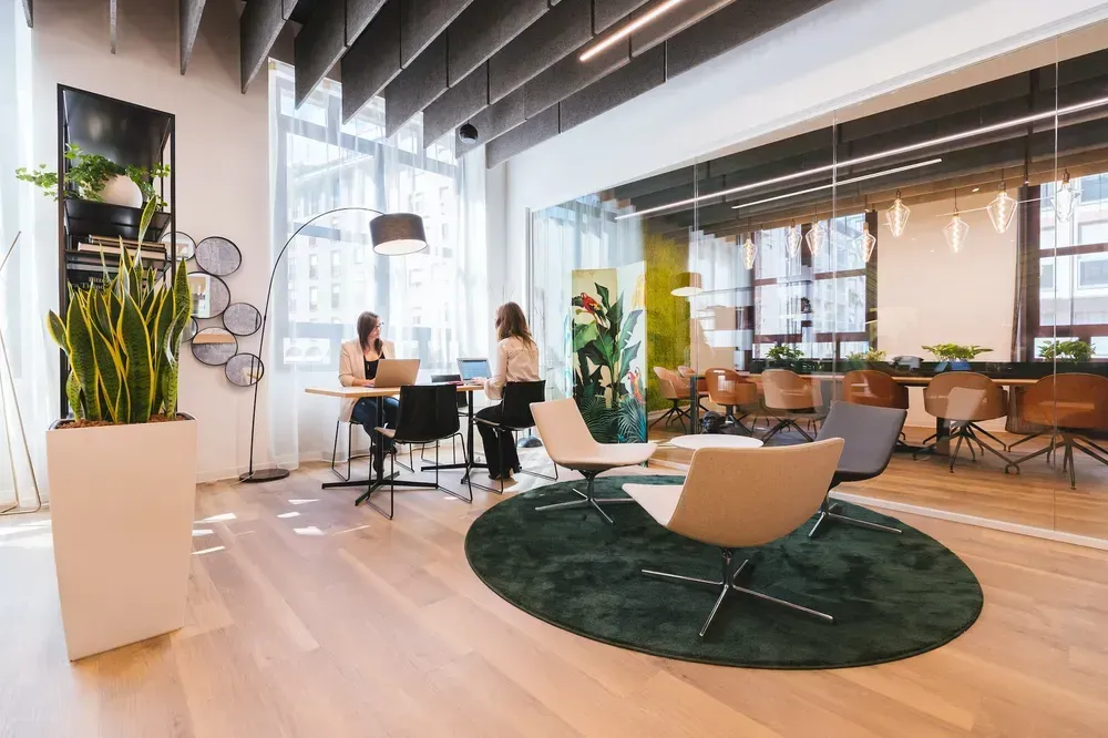 A group of people are sitting at tables in an office.
