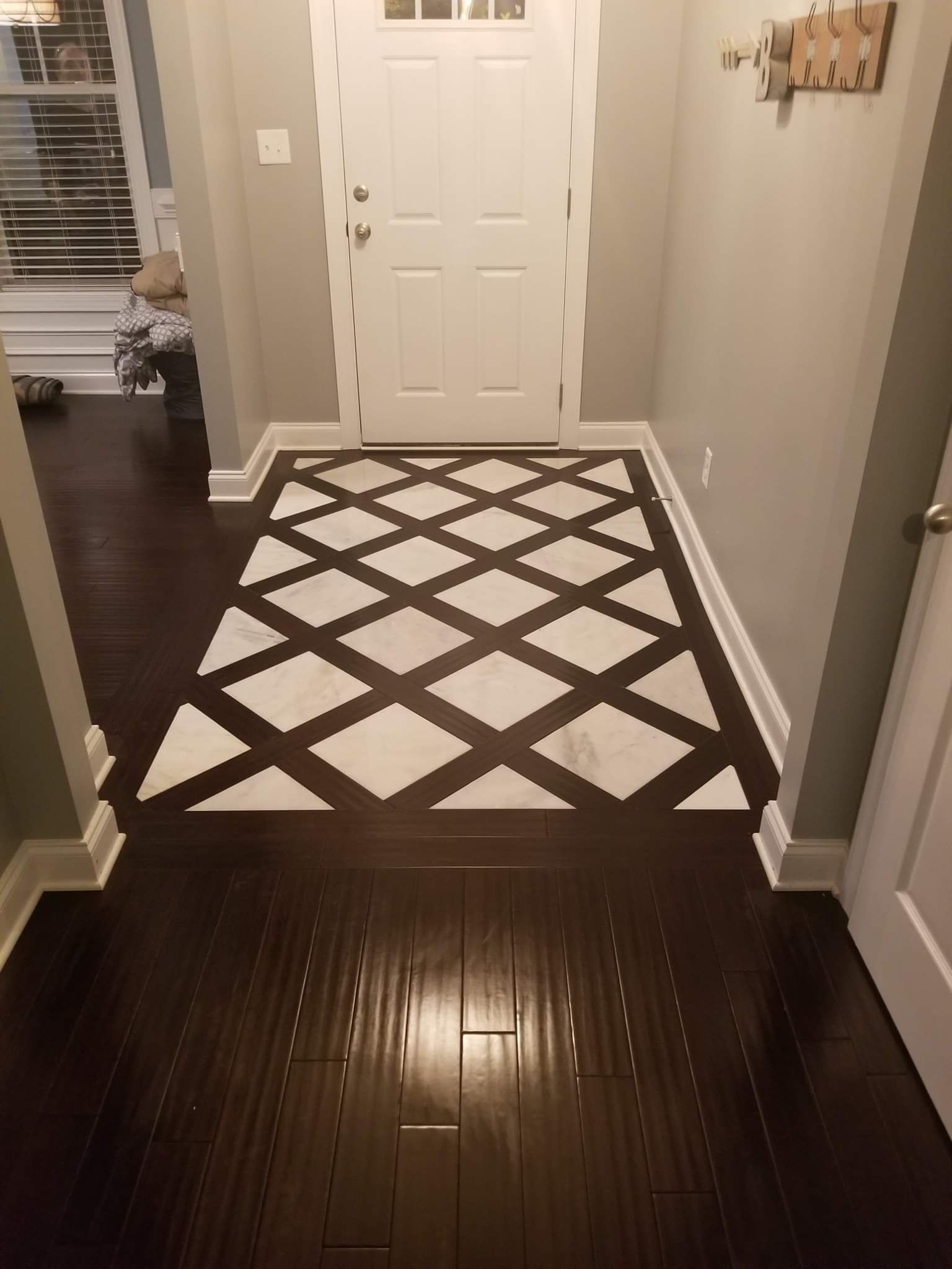 A hallway with a black and white rug on the floor.