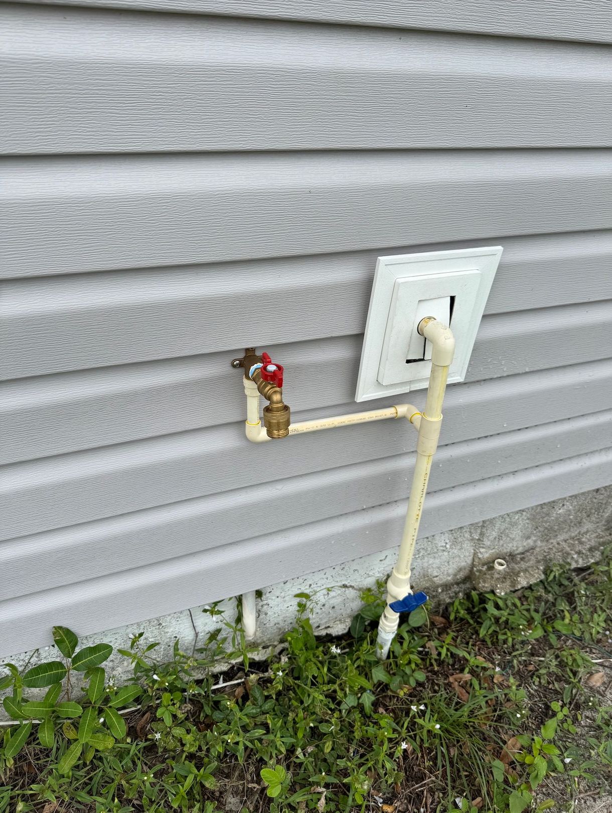 A faucet is attached to the side of a house.